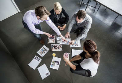 High angle view of business colleagues working with photographs in office