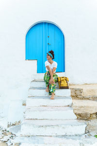 Vertical view of woman with backpack on holidays. woman on stairs on spanish travel destination.