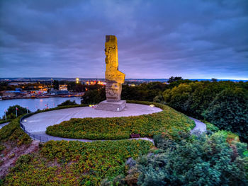 Illuminated sculpture against sky at dusk