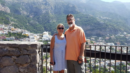 Portrait of mature couple standing by railing