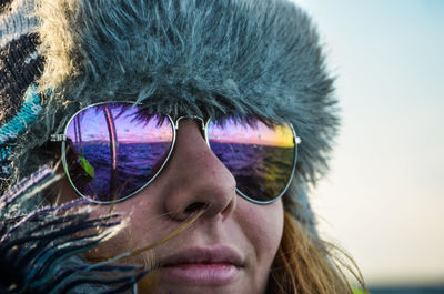 Close-up portrait of young man wearing sunglasses against sky