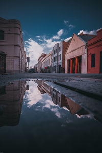 Reflection of buildings in lake against sky