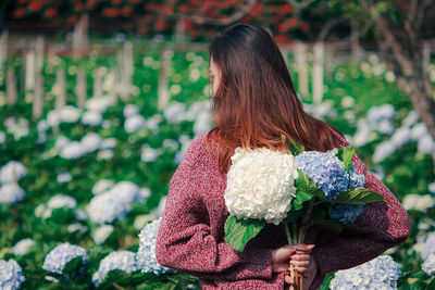 Rear view of woman holding rose bouquet