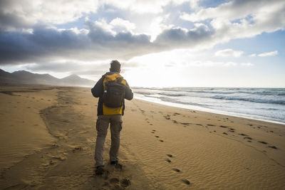 Rear view of man standing on beach