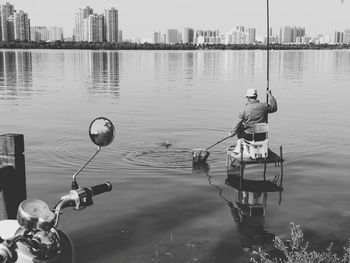 Rear view of man fishing at lake