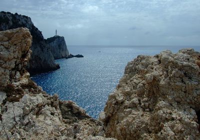 Rock formations by sea against sky