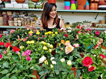 Young woman standing by flowering plants at market stall