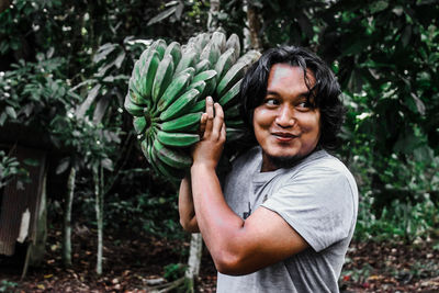 Portrait of smiling man standing against plants