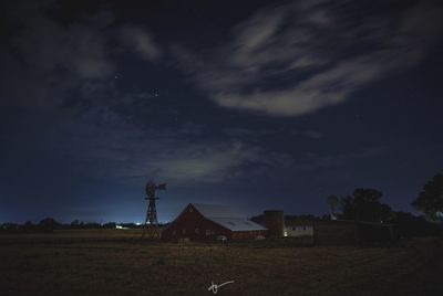 Buildings on field against sky at night