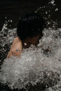 Full length of woman splashing water