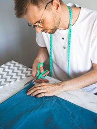 A self-taught seamster in white t-shirt. a tailor cuts fabric. small business, lifestyle concept