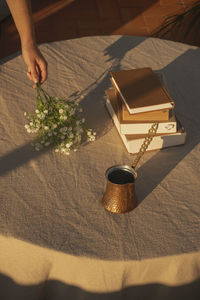 High angle view of hand holding book on table