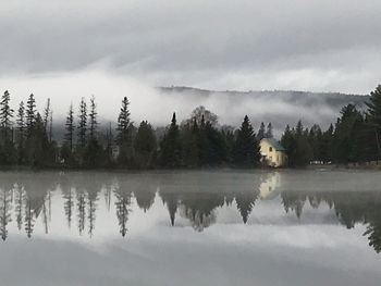 Reflection of trees in lake against sky