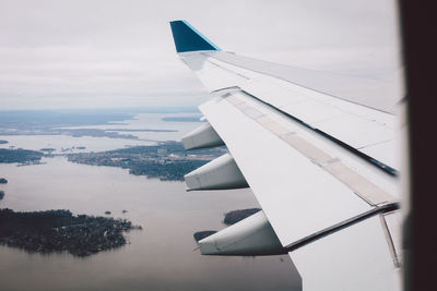 Airplane flying over sea against sky
