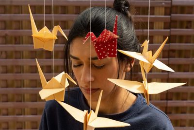 Woman standing by paper origami