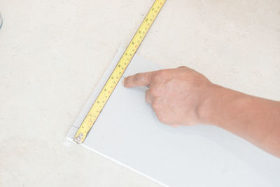 Cropped image of architect measuring with tape measure