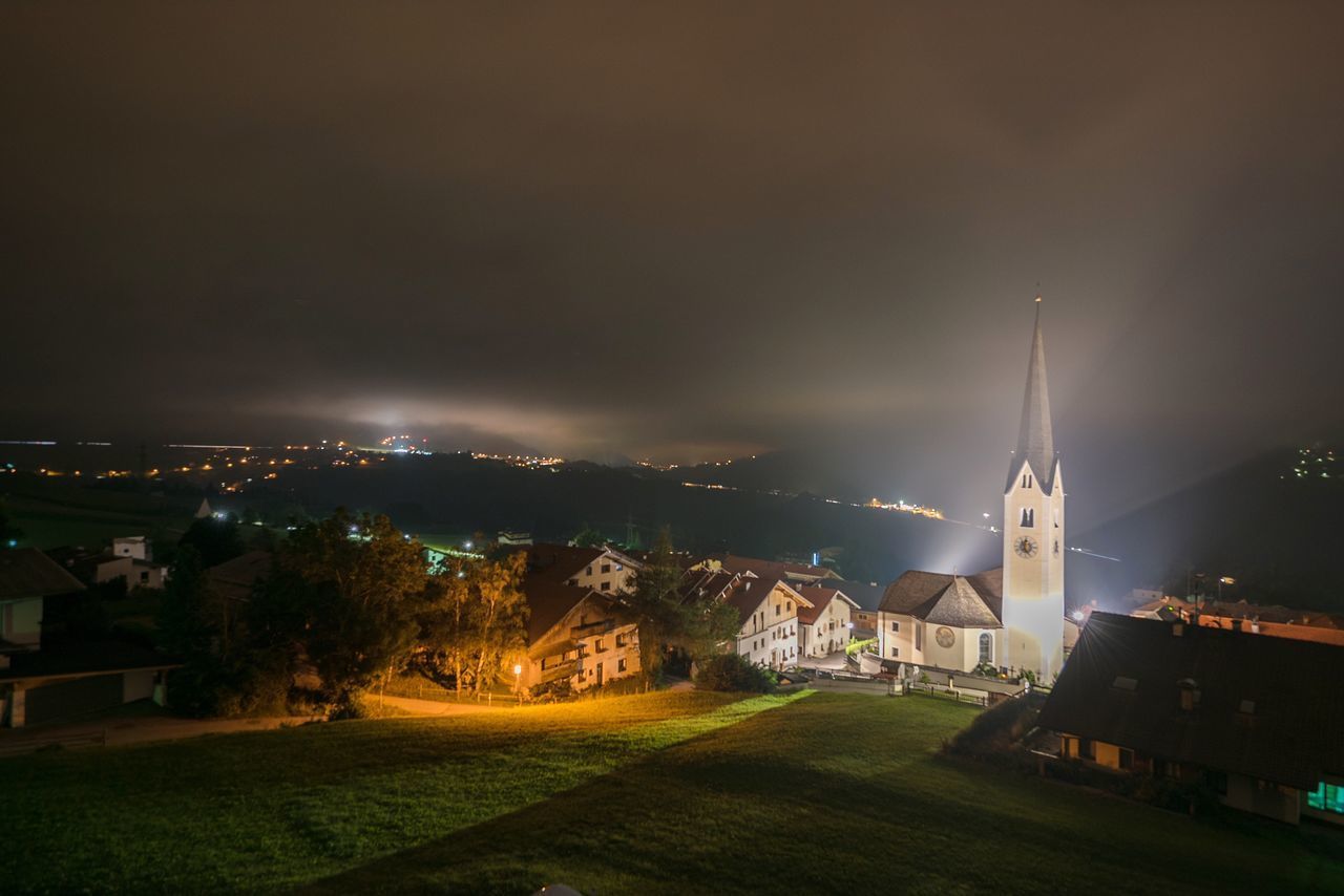 HIGH ANGLE VIEW OF ILLUMINATED CITY BUILDINGS AT NIGHT