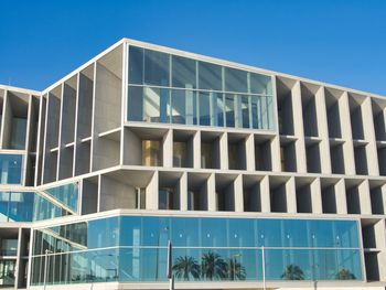 Low angle view of modern building against clear blue sky