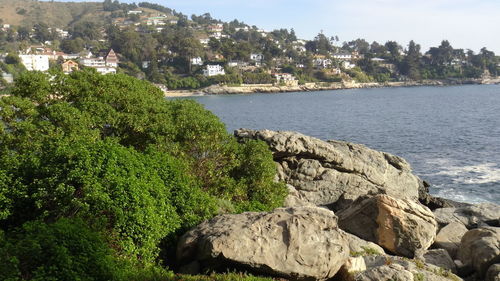 Scenic view of rocks by sea against sky