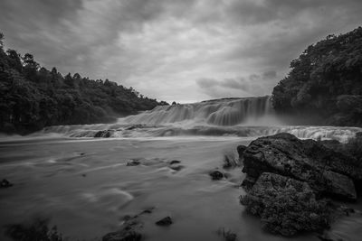 Scenic view of waterfall against sky