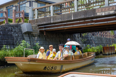 People in boat against canal