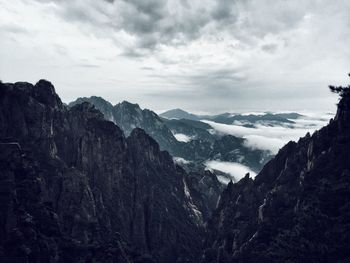 Scenic view of mountains against cloudy sky
