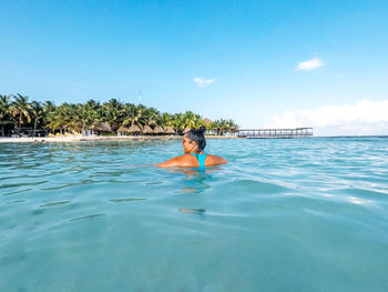 Man swimming in pool against sea