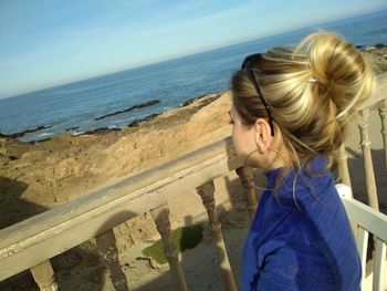 Rear view of girl looking at sea shore