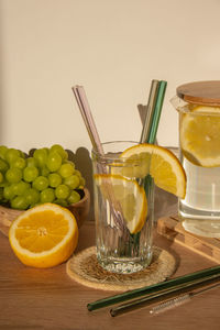 Glass of water with fresh lemon juice with reusable glass straws detox cold tonic water with sunny