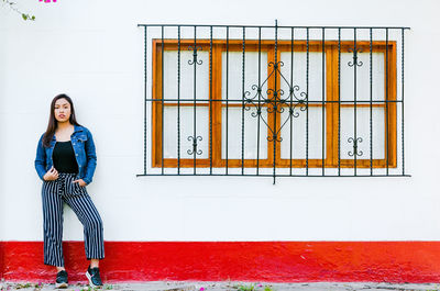 Portrait of woman standing against wall