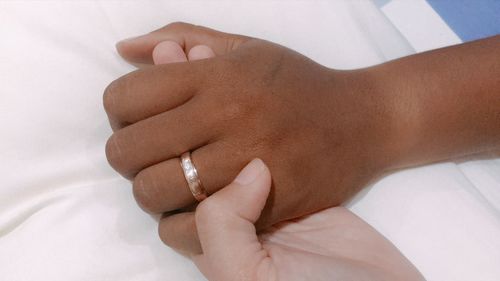 Close-up of woman hand on bed