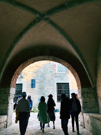 Rear view of people walking in historic building