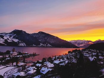 Scenic view of lake and mountains against sky during sunset