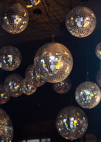 Low angle view of illuminated disco balls hanging from ceiling