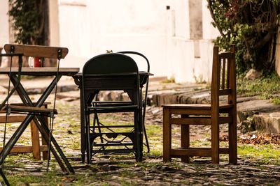 Empty chairs and table in yard against building