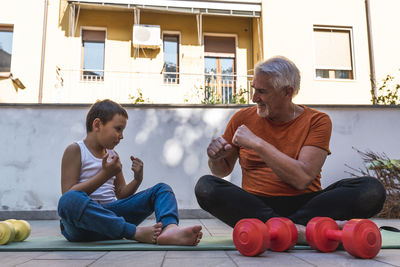 Grandfather and grandson training on terrace