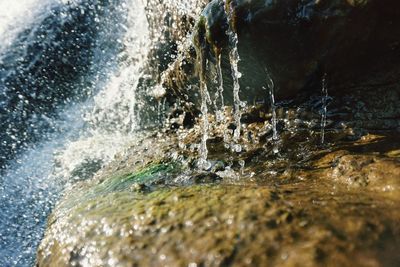 Water splashing on rock during sunny day