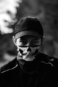 Close-up portrait of man wearing mask and cap