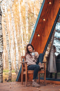 Portrait of young woman sitting on chair outdoors