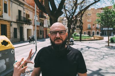 Portrait of man standing on street in city
