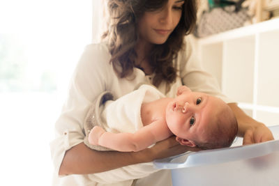 Mother bathing son in bathtub at bathroom