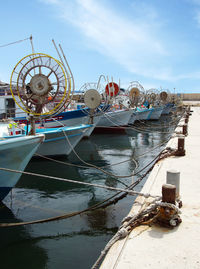 View of boats moored in sea against cloudy sky