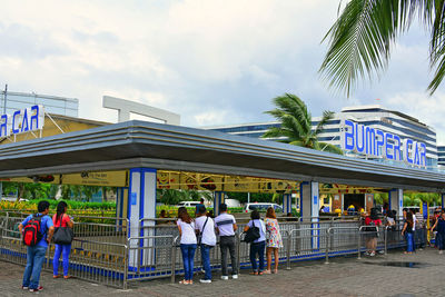 People in front of building against sky