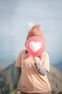 Midsection of woman holding balloons