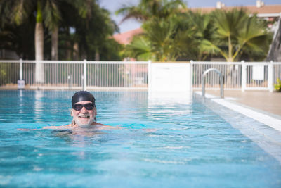 Portrait of senior man swimming in pool