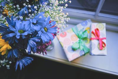 High angle view of bouquet by gift boxes