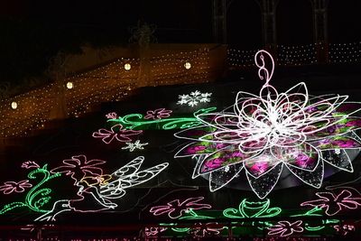 Illuminated christmas lights against sky at night