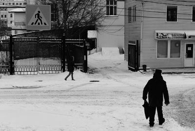 Rear view of man walking on snow