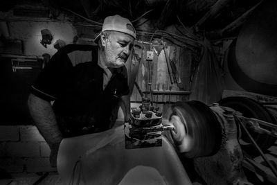 Mature man working on machinery in factory