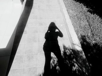 Shadow of people standing on footpath